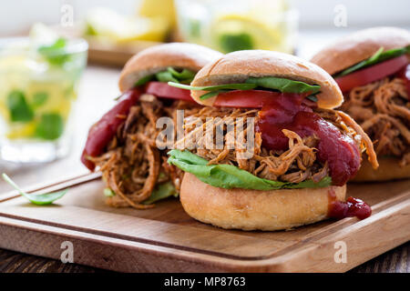 Sandwichs De porc avec les légumes feuilles, tomates sur planche de bois sur une table de pique-nique Banque D'Images