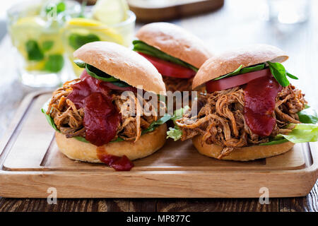 Sandwichs De porc avec les légumes feuilles, tomates sur planche de bois sur une table de pique-nique Banque D'Images