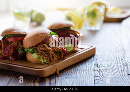 Sandwichs De porc avec les légumes feuilles, tomates sur planche de bois sur une table de pique-nique Banque D'Images