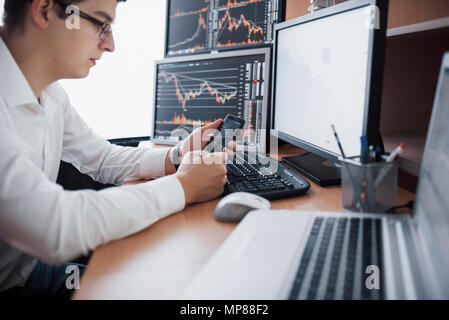 Courtier en shirt travaille dans une salle de surveillance avec des écrans. Forex Trading Bourse Finances Concept graphique. Les stocks d'affaires en ligne trading Banque D'Images