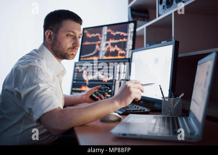 Courtier en shirt travaille dans une salle de surveillance avec des écrans. Forex Trading Bourse Finances Concept graphique. Les stocks d'affaires en ligne trading Banque D'Images