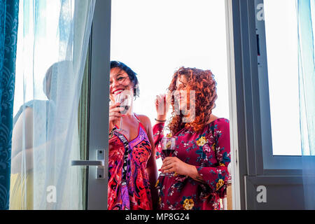 Trois jeunes femmes blanches à la maison en plein air, sur la terrasse faisant partie du temps de célébration et de boire une tasse de vin. sourire et bonheur dans l'amitié Banque D'Images