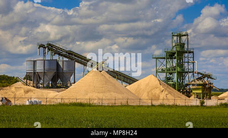 Terminal de l'exploitation du sable avec tapis roulants et silos sur un jour d'été assombri Banque D'Images