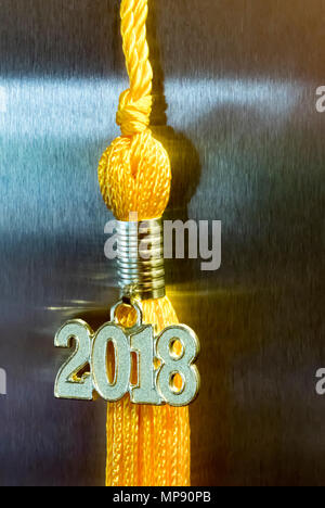 Classe de 2018. Drop tassel or graduation gown accessoire et charme souvenir contre un fond de métal. Symbole d'une réussite du diplômé. Banque D'Images