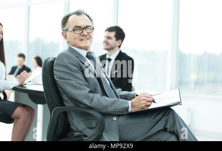 Pensive man in suit avec son équipe travailler derrière Banque D'Images