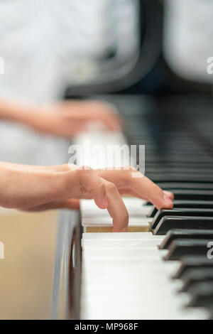 Les mains des enfants jouent du piano. La main de l'enfant sur les touches de piano. Banque D'Images