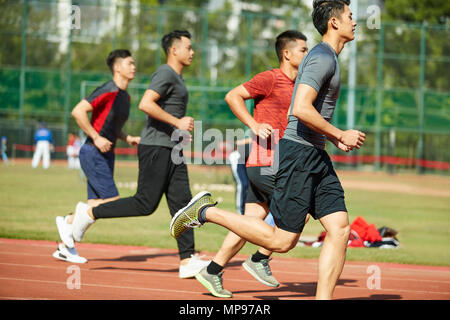 Les jeunes athlètes adultes asiatiques en voie de formation en cours d'exécution, vue de côté. Banque D'Images