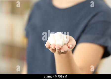 Libre d'une femme main tenant le sucre en cubes à l'appareil photo à la maison Banque D'Images