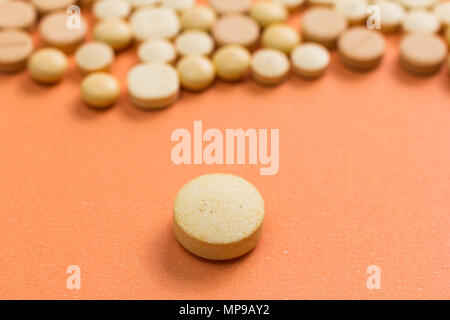 Heap of assorted capsules beige orange sur table. Banque D'Images