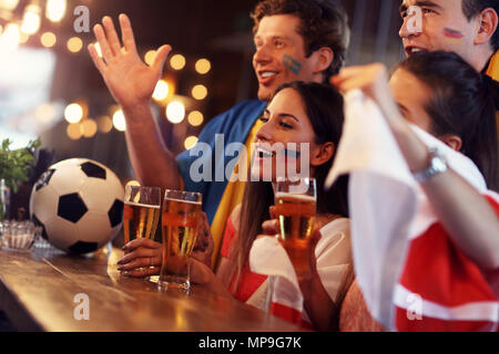 Groupe d'amis regardant jeu de football pub Banque D'Images