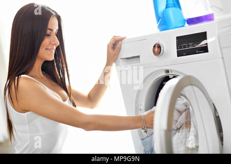 Photo de jeune femme au foyer avec une laverie à côté de lave-linge Banque D'Images