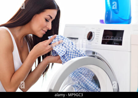 Photo de jeune femme au foyer avec une laverie à côté de lave-linge Banque D'Images