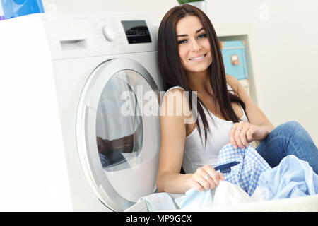 Photo de jeune femme au foyer avec une laverie à côté de lave-linge Banque D'Images