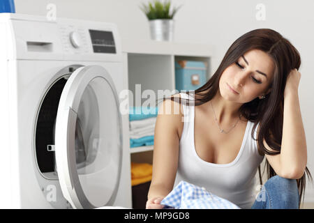 Photo de jeune femme au foyer avec une laverie à côté de lave-linge Banque D'Images