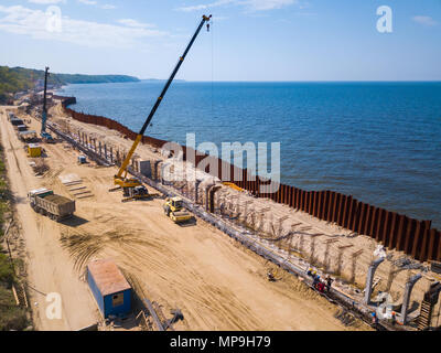Travaux publics pelle sur le bord de la mer, le renforcement du littoral de la mer Baltique Banque D'Images