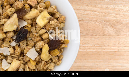 Haut de page Fermer la vue de muesli avec des fruits séchés dans un bol sur une table en bois. Banque D'Images