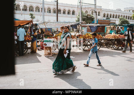 Une mère et son fils en passant devant les charrettes de fruits à Udaipur, Inde Banque D'Images