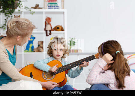 Petit garçon d'âge préscolaire d'apprendre à jouer de la guitare Banque D'Images