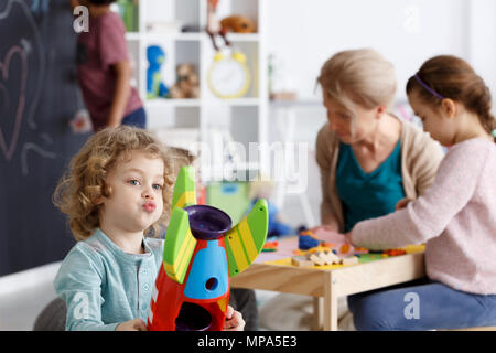 Preschool boy playing with toy rocket colorés Banque D'Images