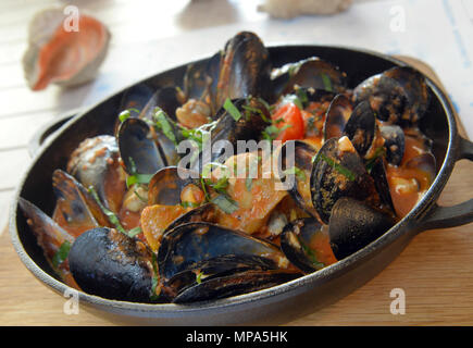 Rapana et des moules dans la sauce tomate dans la casserole. Banque D'Images