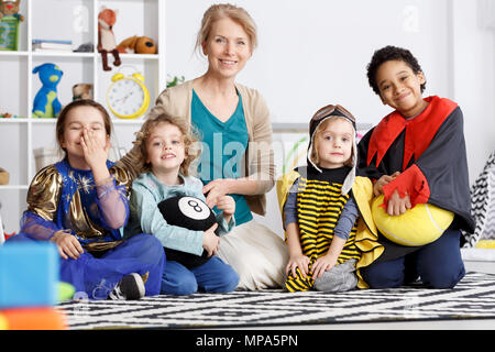 Les enfants d'âge préscolaire de la maternelle group vêtus de costumes colorés Banque D'Images
