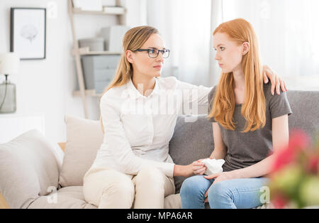 Female therapist réconfortant jeune patient dans son bureau à la clinique psychologique Banque D'Images