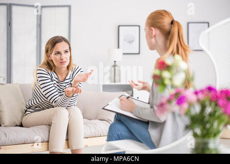 Jeune femme de parler avec le thérapeute en exercice sur les problèmes mentaux et les soucis, le counseling psychology concept Banque D'Images