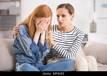 Jeune femme déprimée pleurer être réconforté par l'ami à la maison, fille d'être consolés par soeur, problème mental et la dépression concept Banque D'Images