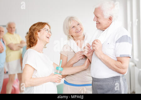 Des amis plus âgés dans une salle de sport à parler après entraînement Banque D'Images