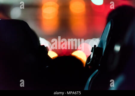 Résumé libre retour de personnes assises dans le bus de tourisme voyage voyage avec nuit sombre soir bokeh coloré couleurs de tunnel, l'éclairage de rue, ou rouge Banque D'Images