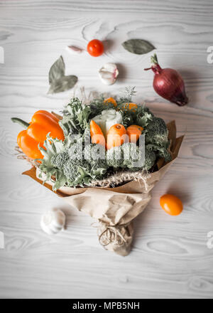 Bouquet de légumes frais se trouve sur une table en bois blanc. A proximité, un oignon rouge, les tomates, l'ail, la feuille de laurier. Vue de dessus. Image tonique Banque D'Images