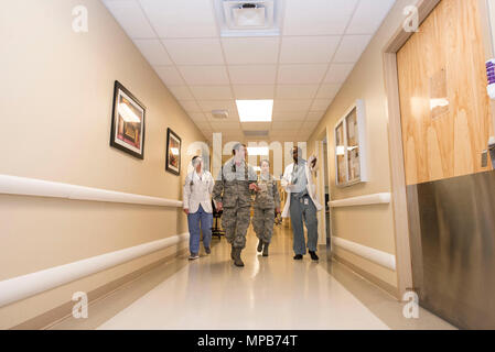 (De gauche à droite) Denisa Jacobs, Kettering Health Network college student, U.S. Air Force Le Major Andrew Maley, 88e Escadron d'opérations médicales médecin médical américain, le capitaine de la Force aérienne, des commandes de Diana Le 88e médical médecin résident et Faysal Abdille, résident en médecine, marcher dans le couloir vers la chambre d'un patient à l'intérieur du centre médical sur la base aérienne de Wright-Patterson, Ohio, le 7 avril 2017. L'IPTS 88e prend en charge six programmes Graduate Medical Education, 13 spécialités médicales chirurgie avec 12, la défense de la patrie et plate-forme de déploiement. Banque D'Images