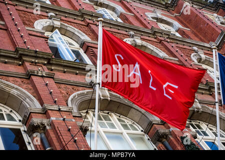 Shopping, vente drapeau rouge volant à Arnotts grand magasin, façade de bâtiment en grès brun, sur Henry Street. Dublin, Irlande, UE. Vue rapprochée, angle bas Banque D'Images