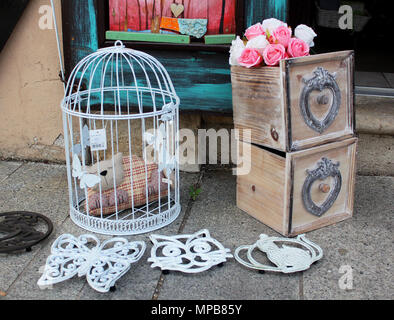 Still Life - cage à oiseaux décorative vintage avec statue d'un chat en bois et boîtes à la main avec roses Banque D'Images