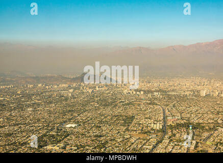 Vue sur Santiago, Chili prises à partir de la fenêtre de l'avion à Cerro San Cristobal et contreforts des Andes cachés par brown couche de smog et de la pollution atmosphérique Banque D'Images