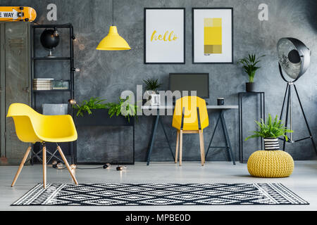 Espace d'étude avec des murs en béton et de jaune et le mobilier métallique Banque D'Images