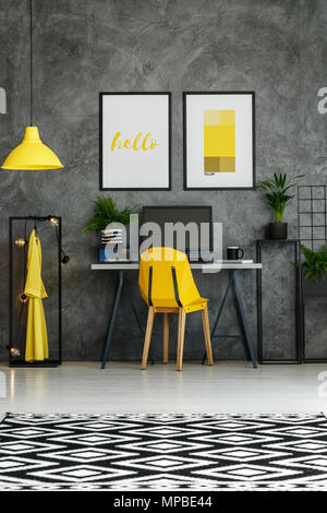 Chambre avec bureau métallique, jaune les accents, textured wall et des maquettes des affiches Banque D'Images