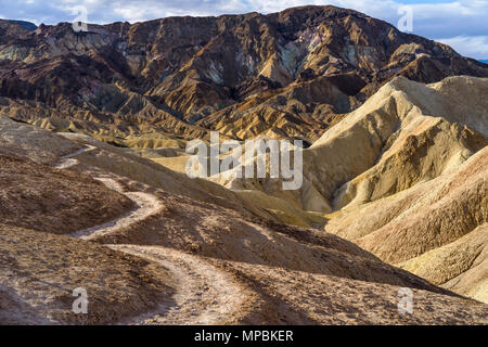 Sentier de la vallée du désert - un matin sur un sentier de randonnée seul enroulement du bord d'une vallée escarpée dans les badlands de la Death Valley National Park, CA, USA Banque D'Images