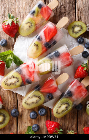 Berry-naturel de glace de fruits frais avec les fraises, les bleuets et les kiwis gros plan sur la table. Haut Vertical Vue de dessus Banque D'Images