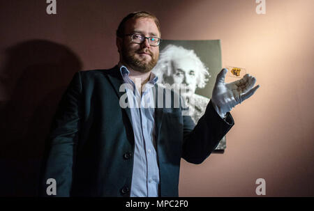 22 mai 2018, l'Allemagne, Münster : Lowell Flenders du Muetter Museum à Philadelphie (USA), tenant une plaque de verre avec un microscopique du tissu du cerveau d'Albert Einstein au Musée westphalien de l'histoire naturelle. L'exposition spéciale "Le cerveau - l'intelligence, la conscience, sentiment" montre les spécimens, parmi eux, des pièces d'Albert Einstein's brain. C'est l'ouverture le 29 juin au Musée d'Histoire Naturelle de Westphalie. Photo : Guido Kirchner/dpa Banque D'Images