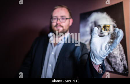 22 mai 2018, l'Allemagne, Münster : Lowell Flenders du Muetter Museum à Philadelphie (USA), tenant une plaque de verre avec un microscopique du tissu du cerveau d'Albert Einstein au Musée westphalien de l'histoire naturelle. L'exposition spéciale "Le cerveau - l'intelligence, la conscience, sentiment" montre les spécimens, parmi eux, des pièces d'Albert Einstein's brain. C'est l'ouverture le 29 juin au Musée d'Histoire Naturelle de Westphalie. Photo : Guido Kirchner/dpa Banque D'Images