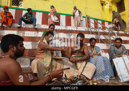 L'Inde, Uttar Pradesh, Varanasi, un pundit effectue une puja pour la famille d'un défunt à Kedar Ghat. Banque D'Images