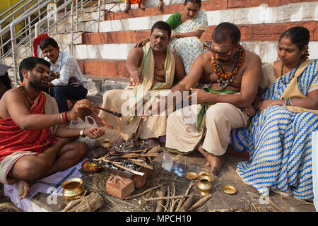 L'Inde, Uttar Pradesh, Varanasi, un pundit effectue une puja pour la famille d'un défunt à Kedar Ghat. Banque D'Images