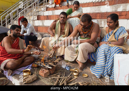 L'Inde, Uttar Pradesh, Varanasi, un pundit effectue une puja pour la famille d'un défunt à Kedar Ghat. Banque D'Images