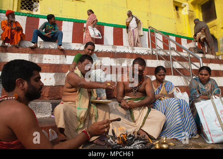 L'Inde, Uttar Pradesh, Varanasi, un pundit effectue une puja pour la famille d'un défunt à Kedar Ghat. Banque D'Images