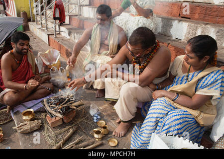 L'Inde, Uttar Pradesh, Varanasi, un pundit effectue une puja pour la famille d'un défunt à Kedar Ghat. Banque D'Images