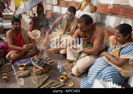 L'Inde, Uttar Pradesh, Varanasi, un pundit effectue une puja pour la famille d'un défunt à Kedar Ghat. Banque D'Images