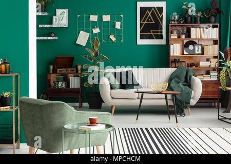 Canapé beige et vert en fauteuil élégant salon intérieur avec ficus et poster Banque D'Images