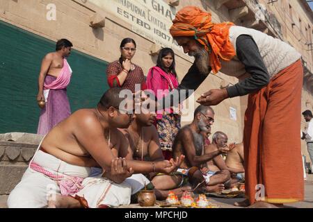 L'Inde, Uttar Pradesh, Varanasi, un saddhu effectue une puja pour la famille d'un défunt sur les ghats. Banque D'Images