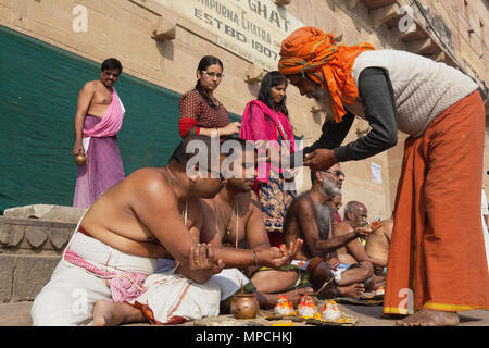 L'Inde, Uttar Pradesh, Varanasi, un saddhu effectue une puja pour la famille d'un défunt sur les ghats. Banque D'Images